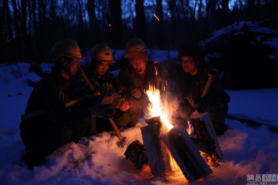 由于雪大路远,工人午餐只能在户外,为了取暖大家经常围着篝火吃饭.